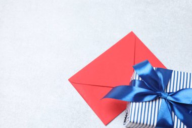 Kırmızı kurdeleli Noel hediyesi kutusu ve beyaz arka planda eğilme.