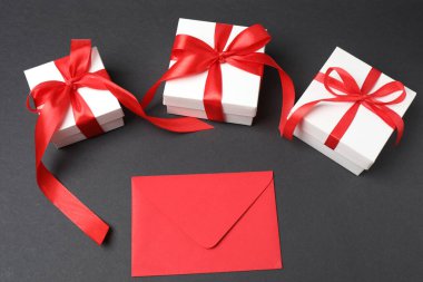 Zarflı hediye kutuları ve beyaz arka planda kurdeleler, yakın plan.