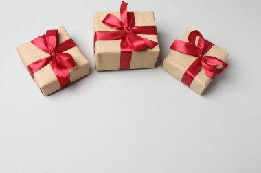 Beyaz arka planda altın fiyonklu kırmızı hediye kutuları, üst manzara.