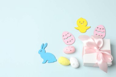 Tavşanlı, hediye kutulu ve mavi kağıtlı yumurtalı mutlu Paskalyalar.