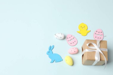 Paskalya kompozisyonu. Paskalya yumurtaları ve beyaz arka planda tavşanlı hediye kutuları. Düz yat. Üst Manzara. Boşluğu kopyala.