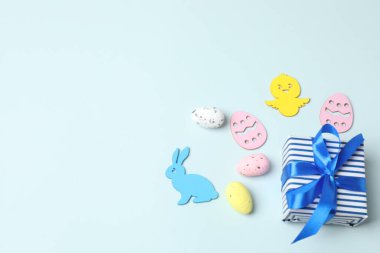 Renkli paskalya yumurtaları ve mavi arka planda tavşanlı yaratıcı düzen, kopya alanı ile düz yatıyordu