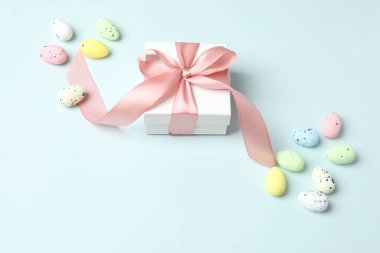 Paskalya yumurtaları ve beyaz arka planda hediye kutusu. Kopyalama alanı olan üst görünüm