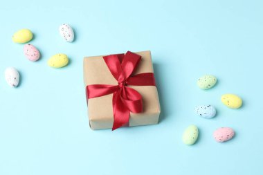 Beyaz kutuda paskalya yumurtaları ve pembe arka planda hediyeler. Paskalya konsepti