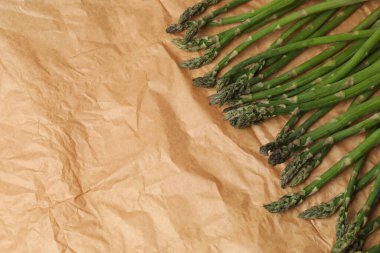 Koyu arkaplanda taze yeşil kuşkonmaz. Üst görünüm, metin için boşluk.