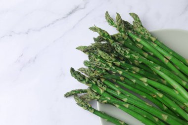 Mermer zemin üzerinde taze yeşil kuşkonmaz