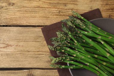 Tahta arka planda taze yeşil kuşkonmaz.