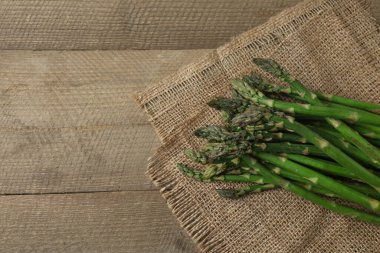 Tahta arka planda taze yeşil kuşkonmaz.