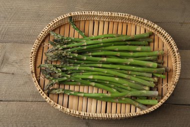 Tahta arka planda taze yeşil kuşkonmaz.