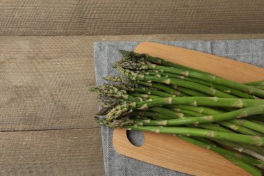 Tahta arka planda taze yeşil kuşkonmaz.