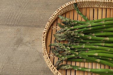 Tahta arka planda taze yeşil kuşkonmaz.