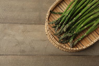 Tahta arka planda taze yeşil kuşkonmaz.