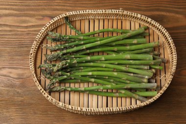 Tahta arka planda taze yeşil kuşkonmaz.
