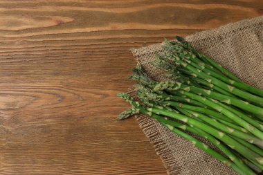 Tahta arka planda taze yeşil kuşkonmaz.