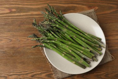 Tahta arka planda taze yeşil kuşkonmaz.