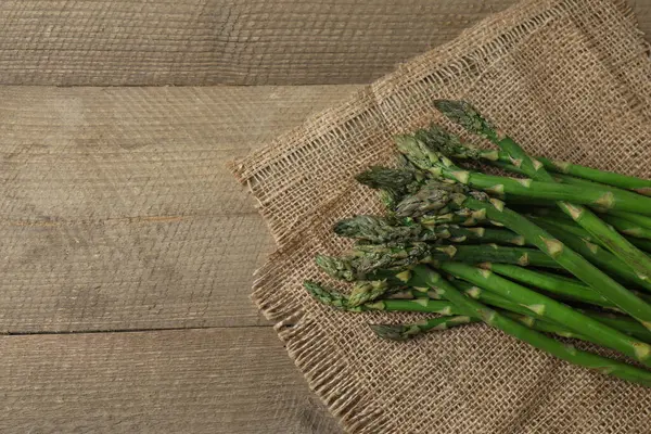 Tahta arka planda taze yeşil kuşkonmaz.