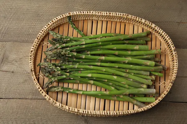 Tahta arka planda taze yeşil kuşkonmaz.