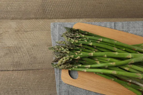 Tahta arka planda taze yeşil kuşkonmaz.