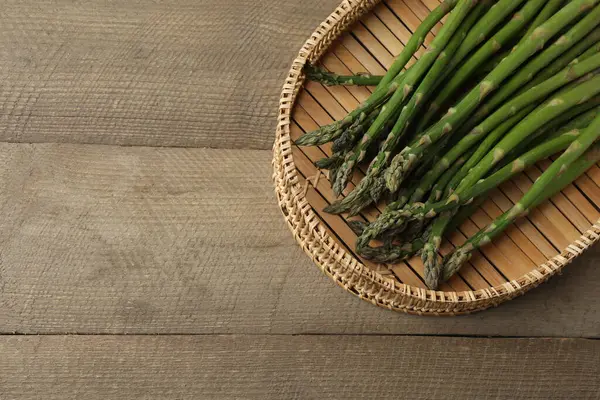 Tahta arka planda taze yeşil kuşkonmaz.
