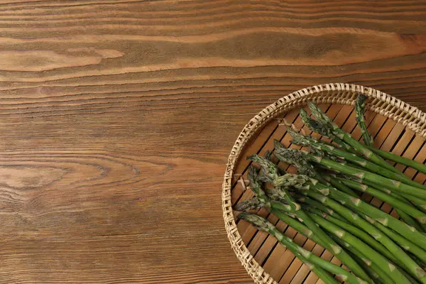 Tahta arka planda taze yeşil kuşkonmaz.