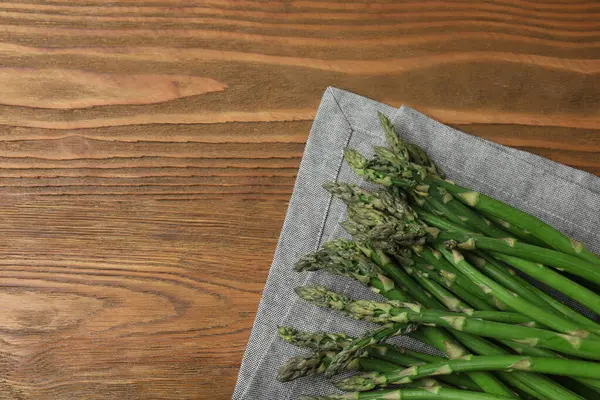 Tahta arka planda taze yeşil kuşkonmaz.