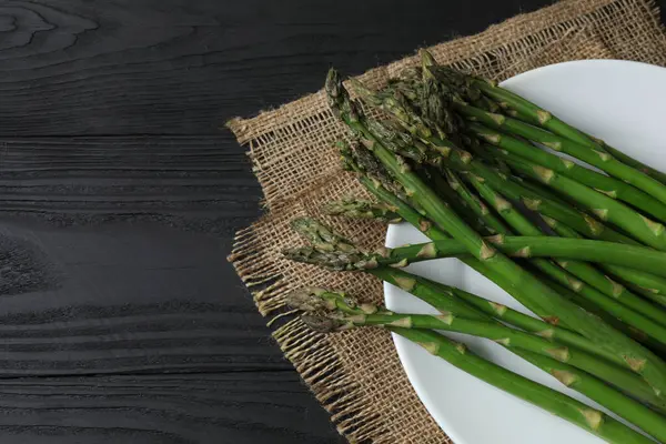 Siyah arka planda taze yeşil kuşkonmaz