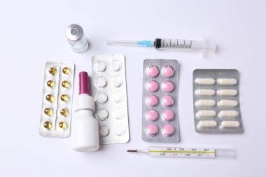 Beyaz arka planda farklı haplar ve kapsüller.