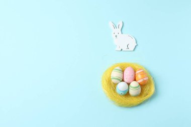 İzole edilmiş pembe arka planda bir yuvadaki paskalya yumurtaları. Mutlu Paskalyalar. Üst görünüm, boşluk kopyala.