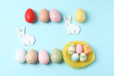 Paskalya kompozisyonu. Açık mavi arka planda farklı paskalya tavşanları var. Metin için boşluk