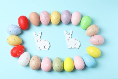 Pastel mavi arka planda paskalya yumurtaları ve tavşan kulakları