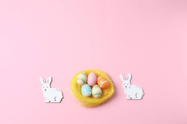 Renkli arka planda Paskalya tavşanı ve renkli yumurtalar.