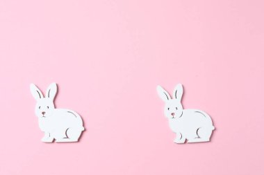 Paskalya arka planı. Pembe arka planda beyaz tavşan ve pembe yumurtalar.