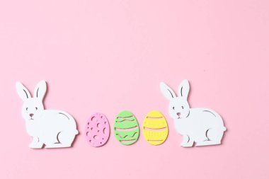 Paskalya tavşanı, paskalya yumurtası ve pembe pastel arka planda tavşan..