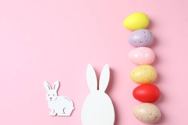 Paskalya yumurtaları, tavşancık ve tavşancık pembe ve beyaz arka planda, üst manzara