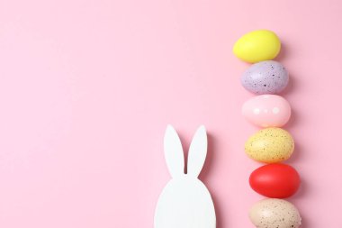 Paskalya yumurtası ve tavşancık pastel arka planda, üst manzara.