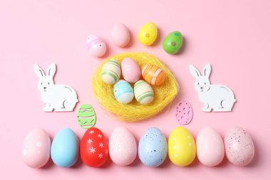Paskalya tatili konsepti. Renkli Paskalya tavşanı, Paskalya yumurtası, pembe arka planda tavşan ve yuva.