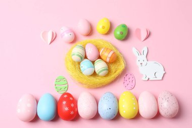 Renkli paskalya arkaplanı. Paskalya tavşanı ve pastel pembe arka planda yumurtalar. Üst görünüm düzlüğü