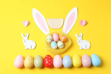 Renkli arkaplanda Paskalya tavşanı, yumurta ve tatlı kompozisyonu