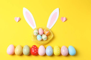 Paskalya yumurtaları ve renkli kulakları olan sevimli bir tavşan.