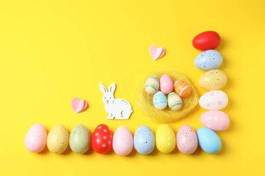 Sarı arka planda tavşanlı renkli Paskalya yumurtaları
