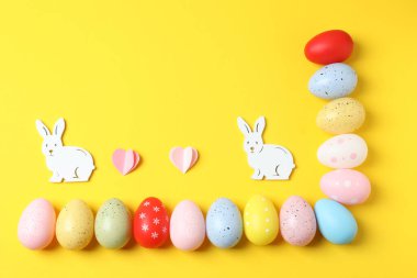 Sarı arka planda paskalya yumurtası ve tavşan