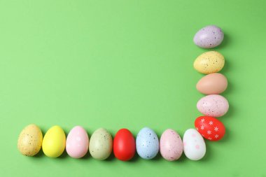 Renkli boyalı paskalya yumurtaları pastel pembe arka planda.