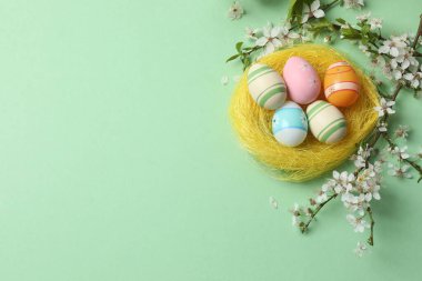 Renkli yumurta ve söğüt dallı paskalya kompozisyonu.