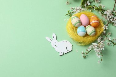 Paskalya yumurtalarının düz görüntüsü ve söğüt dalları. Pembe arka planda tavşan kulakları ve fotokopi alanı.