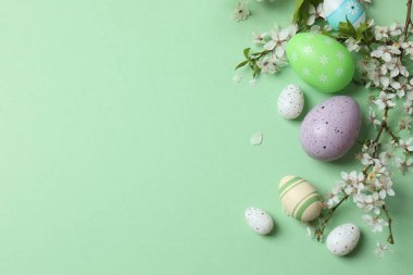 Yeşil arka planda paskalya yumurtası ve bahar çiçeği. Paskalya tatili konsepti.