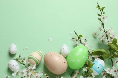 Yeşil zemin üzerinde yumurta ve bahar çiçekleri olan paskalya kompozisyonu