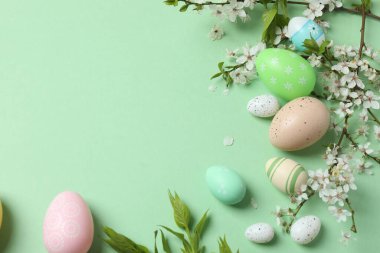 Pastel arka planda paskalya yumurtası ve çiçekler.