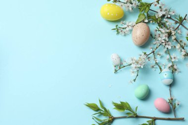 Renkli yumurta ve çiçekli paskalya arkaplanı. Kopyalama alanı olan üst görünüm. düz yat.