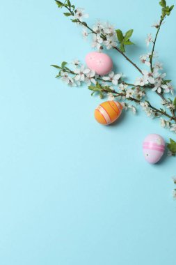 Mavi Arkaplanda Paskalya Yumurtaları ve Çiçekler.