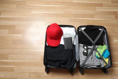 Bavul, şapka ve güneş gözlüğü, ahşap bavulun yanında.